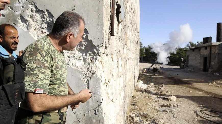 Colonel Abdul-Jabbar al-Aqidi, commander of the rebels’ Military Council in Aleppo, launches a mortar shell at the frontline in the Al-Sakhour neighborhood of Aleppo, June 21, 2013. REUTERS/Muzaffar Salman   (SYRIA - Tags: POLITICS CIVIL UNREST) - RTX10WGT