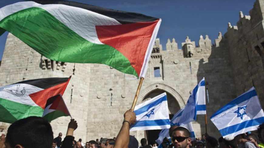 Palestinian protesters wave Palestinian flags as Israelis carrying Israeli flags walk past in front of the Damascus Gate outside Jerusalem's Old City during a parade marking Jerusalem Day May 8, 2013. Jerusalem Day marks the anniversary of Israel's capture of the Eastern part of the city during the 1967 Middle East War. In 1980, Israel's parliament passed a law declaring united Jerusalem as the national capital, a move never recognised internationally. There were confrontations on Wednesday between Muslims 