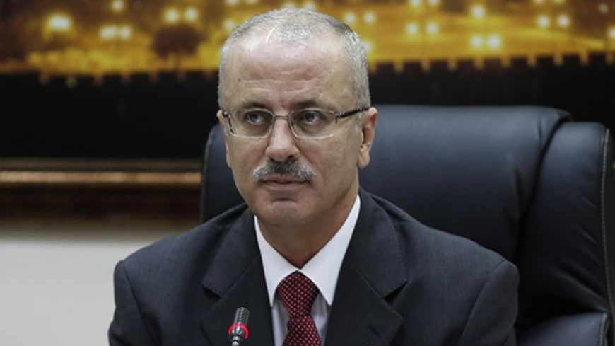 Newly sworn-in Palestinian Prime Minister Rami Hamdallah heads his first cabinet meeting in the West Bank city of Ramallah June 11, 2013. REUTERS/Mohamad Torokman (WEST BANK - Tags: POLITICS) - RTX10J9O