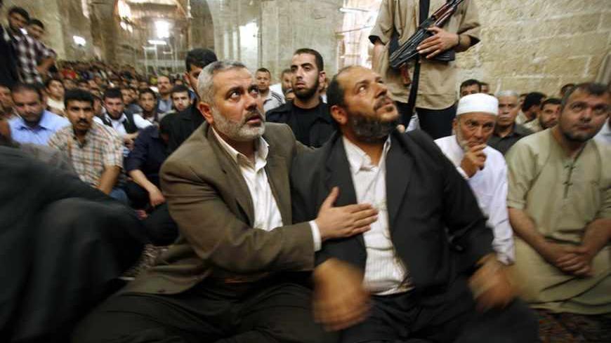 Palestinian Prime Minister Ismail Haniyeh (front, L) hugs Hamas politician Khalil al-Hayya during the funeral for seven of al-Hayya's relatives in Gaza May 21, 2007. Israel launched more strikes against Gaza militants on Sunday, killing nine Palestinians in two aerial assaults, including one that struck the home of al-Hayya, security officials said. REUTERS/Suhaib Salem (GAZA) - RTR1PXEC
