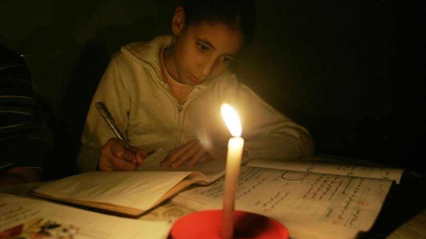 A Palestinian girl studies by candle light during a power cut in Gaza November 13, 2008 November 13, 2008. A United Nations aid agency said on Thursday it had run out of food supplies for 750,000 Palestinians in the Hamas-run Gaza Strip after Israel blocked deliveries by the world body.Short of fuel, Palestinian officials shut down Gaza's sole power plant as Israel kept commercial crossings with the coastal territory closed for a 10th day.  REUTERS/Ismail Zaydah (GAZA) - RTXAK2X