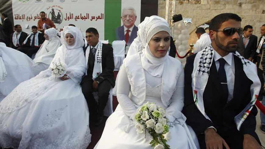 Palestinian couples participate in a mass wedding in the West Bank city of Nablus May 12, 2011. A group of 22 couples, some disabled, participated in the wedding ceremony which was sponsored by the United Arab Emirates. REUTERS/Abed Omar Qusini (WEST BANK - Tags: SOCIETY) - RTR2MBU0