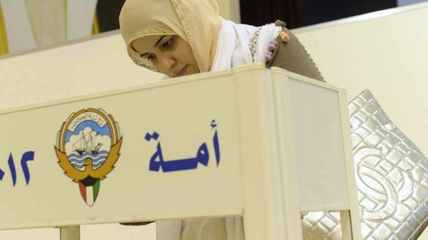 A woman votes at a polling station in Kuwait city February 2, 2012. Kuwaitis headed to the polls on Thursday for the fourth time in six years in a snap parliamentary election in which opposition candidates expect to expand their influence and push for change in the oil-exporting Gulf Arab state.  REUTERS/Stringer    (KUWAIT - Tags: POLITICS ELECTIONS) - RTR2X7TI