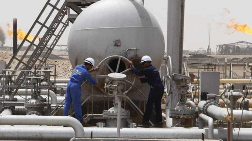 Workers of South Oil Company (SOC) adjust a valve at the Rumaila oil field in Basra Province in this May 24, 2010 file photo. The initial development plan agreed by Exxon Mobil and its partners for Iraq's West Qurna Phase One oilfield included drilling eight new wells and overhauling up to 50 wells this year to boost output. Exxon Mobil wants to leave its flagship Iraqi oil project after upsetting Baghdad by signing a deal last year with the autonomous northern Kurdish region, which the central government d