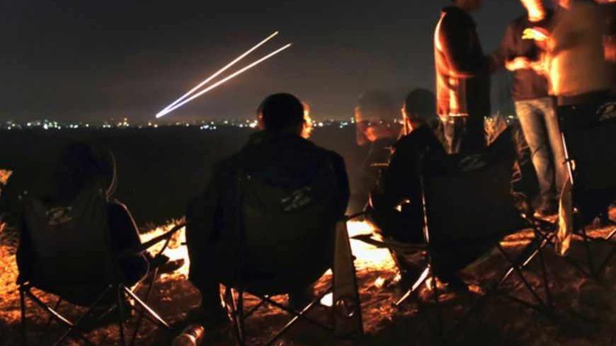 Israeli civilians sitting atop a hill in the city of Sderot watch as two Palestinian rockets fly towards southern Israel, before a ceasefire November 21, 2012. Israel and the Islamist Hamas movement ruling the Gaza Strip agreed on Wednesday to an Egyptian-sponsored ceasefire to halt an eight-day conflict that killed 162 Palestinians and five Israelis.  REUTERS/Yannis Behrakis (ISRAEL - Tags: CONFLICT POLITICS TPX IMAGES OF THE DAY) - RTR3APKM