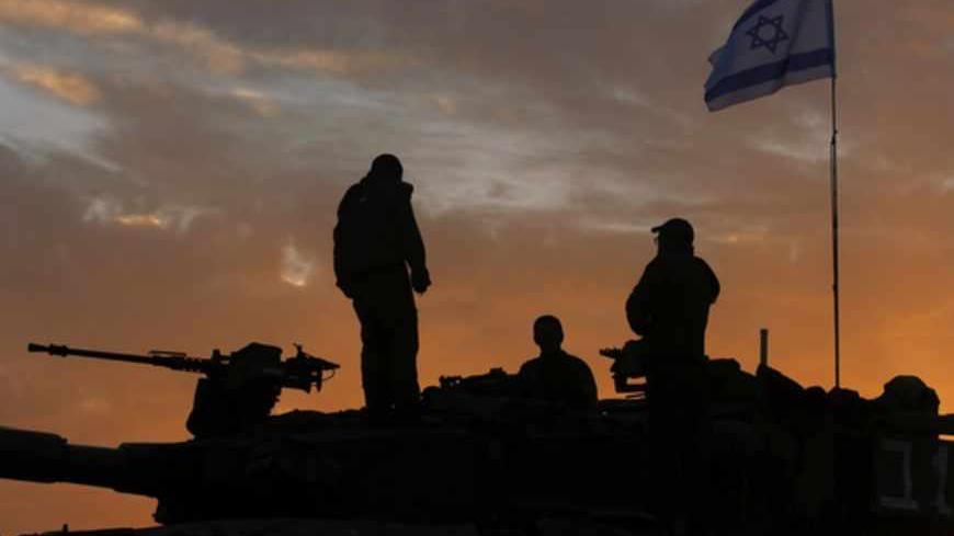 Israeli soldiers, atop a tank, prepare to leave their Gaza border position at sun rise November 22, 2012. A ceasefire between Israel and Gaza's Hamas rulers took hold on Thursday after eight days of conflict, although deep mistrust on both sides cast doubt on how long the Egyptian-sponsored deal can last.  REUTERS/Yannis Behrakis (ISRAEL - Tags: CONFLICT POLITICS) - RTR3AQ08