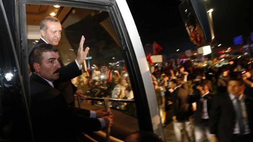 Turkey's Prime Minister Tayyip Erdogan (2nd L) waves to supporters after arriving at Istanbul's Ataturk airport early June 7, 2013. Erdogan called on Turks on Friday to distance themselves from lawless protests and said accusations of the excessive use of police force during days of unrest were being investigated. Addressing thousands of supporters at Istanbul airport after returning from a trip to North Africa, Erdogan said the protesters had looted shops and damaged businesses and urged his supporters not