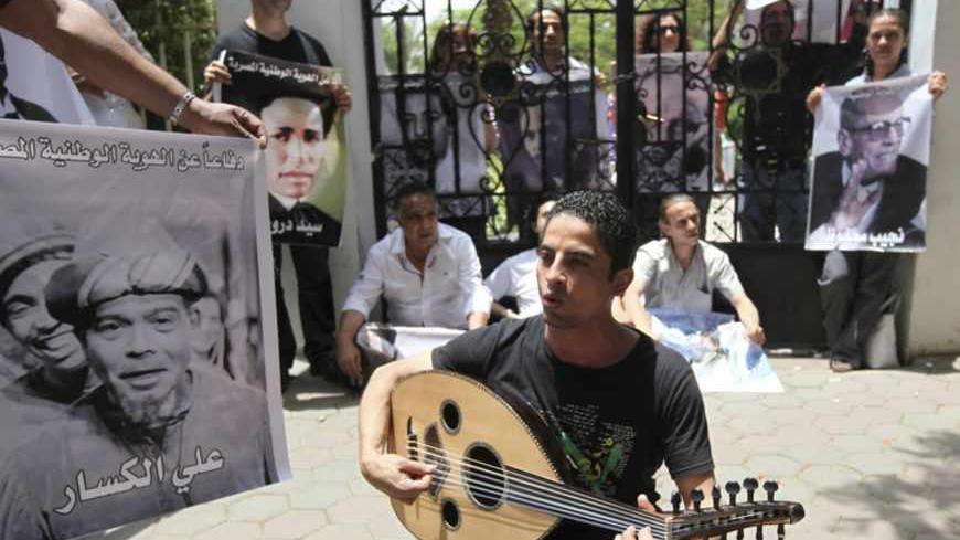 Intellectuals and artists, who are anti-Mursi protestors, carry pictures of some of the popular Egyptian artists and writers as they demonstrate in front of the Ministry of Culture against what they claimed are increasing influence of the Muslim Brotherhood over the Ministry of Culture, in Cairo June 9, 2013. Egyptian President Mohamed Mursi increased the influence of his Muslim Brotherhood over government in a cabinet reshuffle in May that replaced two ministers involved in crucial talks with the IMF over 