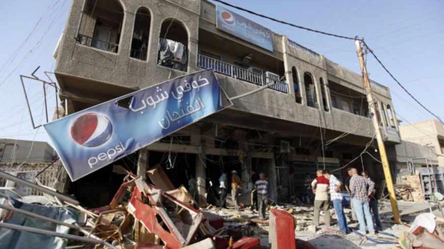 Residents gather at the premises of a coffee shop that was destroyed in a suicide bomb attack the night before, in Baghdad June 17, 2013. Five people were killed and 20 were wounded in the attack, police said.                   REUTERS/Saad Shalash (IRAQ - Tags: CIVIL UNREST TPX IMAGES OF THE DAY) - RTX10QGM