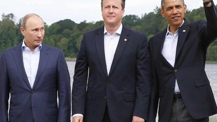 Russia's President Valdimir Putin (L) looks at Britain's Prime Minister David Cameron and U.S. President Barack Obama during a family photo at the G8 Summit, at Lough Erne, near Enniskillen, in Northern Ireland June 18, 2013.  REUTERS/Yves Herman (NORTHERN IRELAND - Tags: POLITICS) - RTX10S1Z