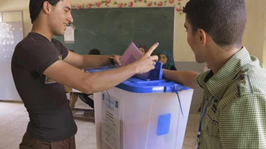 A youth casts his vote into a ballot box during the Iraq's provincial elections at a polling station in Ramadi, 100 km (62 miles) west of Baghdad, June 20, 2013. REUTERS/Ali al-Mashhadani (IRAQ - Tags - Tags: ELECTIONS POLITICS) - RTX10ULM