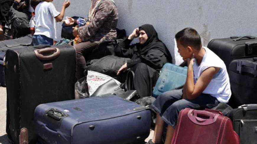 Palestinian passengers wait to cross into Egypt at Rafah crossing in the southern Gaza Strip June 24, 2013. The crossing was experiencing slow passage movement, passengers said. REUTERS/Ibraheem Abu Mustafa (GAZA - Tags: POLITICS SOCIETY) - RTX10Z0W