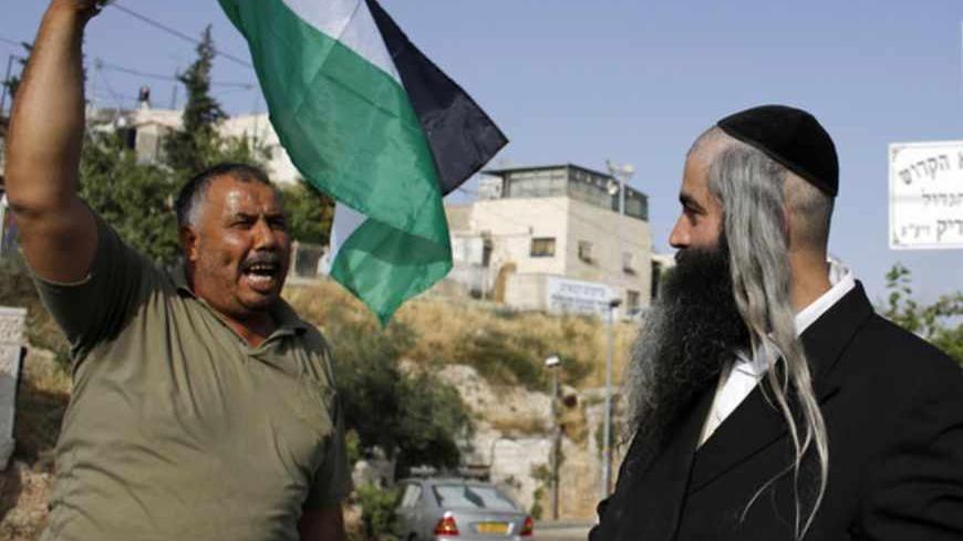A protester waving a Palestinian flag shouts at an Orthodox Jewish man in the Sheikh Jarrah neighborhood of East Jerusalem May 17, 2013, during a weekly demonstration against Jewish settlements and the possible eviction of a Palestinian family from their home. REUTERS/Ammar Awad (JERUSALEM - Tags: POLITICS CIVIL UNREST) - RTXZQQB
