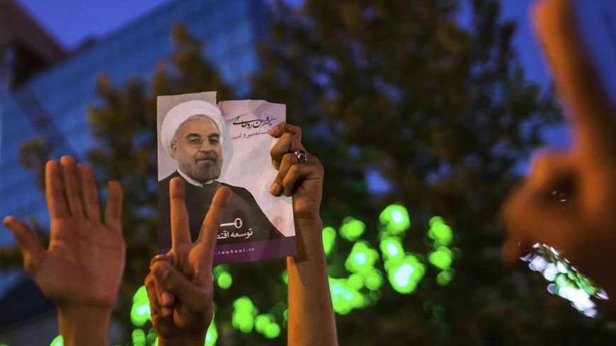 Supporters of moderate cleric Hassan Rohani hold a picture of him as they celebrate his victory in Iran's presidential election on a pedestrian bridge in Tehran June 15, 2013. Rohani won Iran's presidential election on Saturday, the interior ministry said, scoring a surprising landslide victory over conservative hardliners without the need for a second round run-off. REUTERS/Fars News/Sina Shiri (IRAN - Tags: POLITICS ELECTIONS)  ATTENTION EDITORS - THIS IMAGE WAS PROVIDED BY A THIRD PARTY. FOR  EDITORIAL U