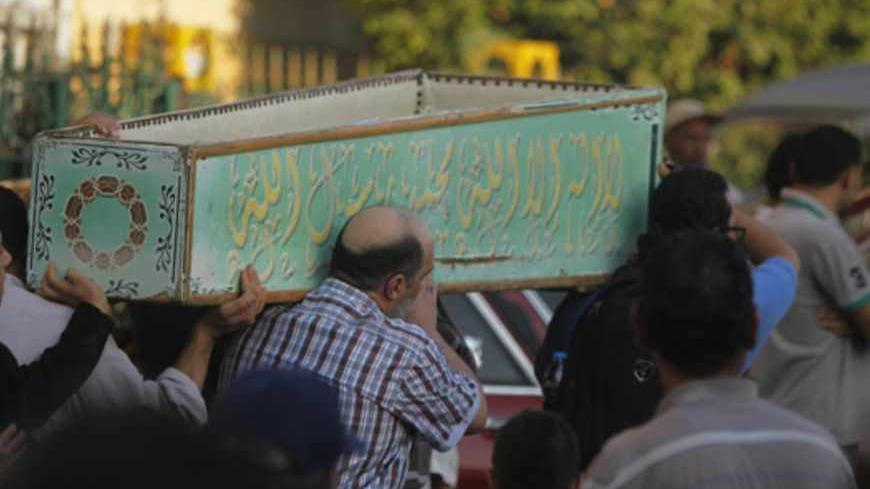 Egyptians carry the coffin of a Shi'ite victim, who was killed in sectarian violence, after funeral prayers in El Sayeda Nafisa Mosque in Cairo, June 24, 2013. Egypt's president, accused of fuelling sectarian hatred, promised swift justice on Monday for a deadly attack on minority Shi'ites as he tried to quell broader factional fighting to avoid a threatened military intervention. REUTERS/Amr Abdallah Dalsh  (EGYPT - Tags: POLITICS CIVIL UNREST RELIGION) - RTX10ZDY
