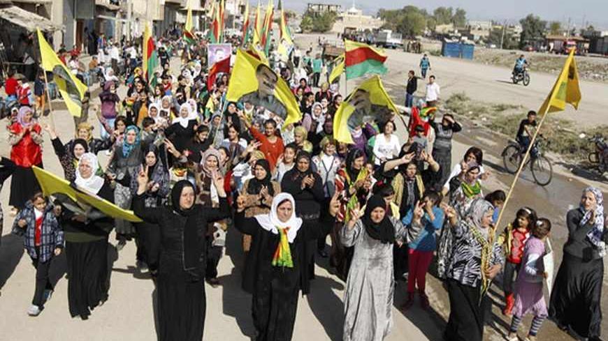 Syrian Kurds demonstrators hold flags and portraits of jailed Kurdistan Workers Party (PKK) leader Abdullah Ocalan during a protest in Derik, Hasakah November 1, 2012. Around 1,000 Syrian Kurds protested in the north-eastern Syrian town of Derik on Thursday, demanding the re-opening of Kurdish-language schools they said were closed by President's Bashar al-Assad's regime.  REUTERS/Thaier al-Sudani (SYRIA - Tags: POLITICS CIVIL UNREST CONFLICT EDUCATION) - RTR39VNY