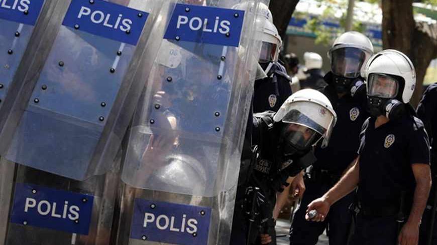 Riot police hide behind their shields during clashes with demonstrators during a protest against Turkey's Prime Minister Tayyip Erdogan and his ruling Justice and Development Party (AKP) in central Ankara June 1, 2013. Erdogan made a defiant call for an end to the fiercest anti-government demonstrations in years on Saturday, as thousands of protesters clashed with riot police in Istanbul and Ankara for a second day.     REUTERS/Umit Bektas (TURKEY - Tags: POLITICS CIVIL UNREST) - RTX1088W
