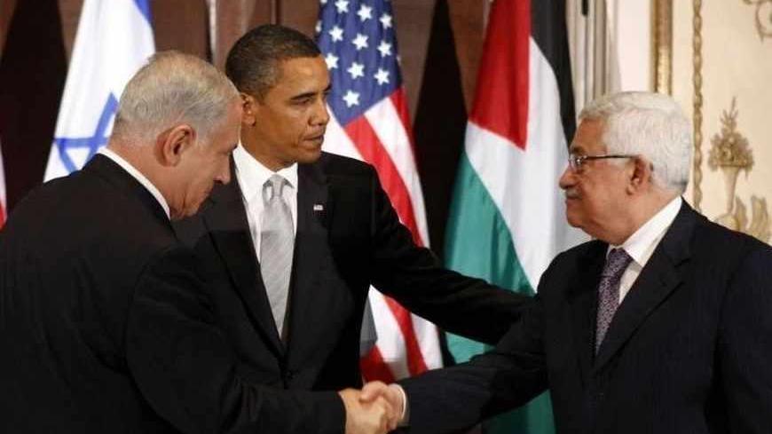 Israeli Prime Minister Benjamin Netanyahu (L) shakes hands with Palestinian President Mahmoud Abbas in front of U.S. President Barack Obama (C) during a trilateral meeting at President Obama's hotel in New York September 22, 2009. Obama, making his most direct foray into Middle East diplomacy, on Tuesday called Israelis and Palestinians to act with a sense of urgency to get formal peace negotiations back on track.    REUTERS/Kevin Lamarque (UNITED STATES POLITICS) - RTR285E9