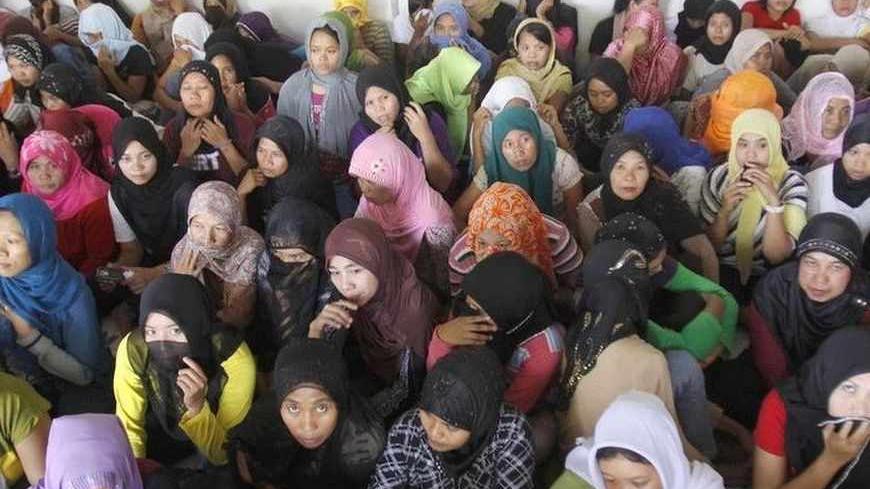 Indonesian workers ready to fly to Saudi Arabia to work as maids wait at a shelter during a police inspection in Bekasi, Indonesia's West Java province, June 22, 2011.  Indonesian President Susilo Bambang Yudhoyono decide to apply a moratorium on sending Indonesian workers to Saudi Arabia be effect on August 1 after a 54-year-old Indonesian maid was beheaded on Saturday, convicted of murdering her Saudi employer, Yudhoyono said on Thursday on a live TV broadcast. Picture taken June 22, 2011.   REUTERS/Sulth