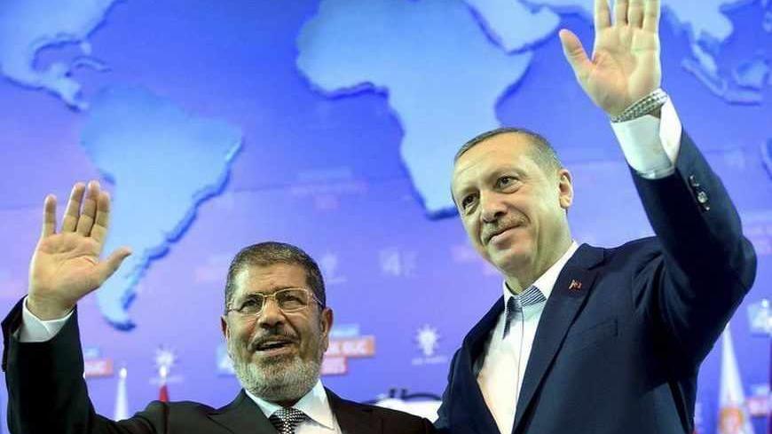Turkey's Prime Minister and leader of ruling Justice and Development Party (AKP) Tayyip Erdogan (R) and his guest Egypt's President Mohamed Mursi greet the audience during AK Party congress in Ankara September 30, 2012. Erdogan trumpeted Turkey's credentials as a rising democratic power on Sunday, saying his Islamist-rooted ruling party had become an example to the Muslim world after a decade in charge. Addressing thousands of party members and regional leaders at a congress of his Justice and Development (