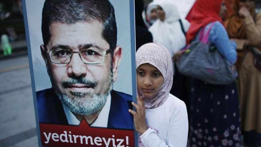A girl holds a poster of Egypt's President Mohamed Mursi during a pro-Islamist demonstration in Istanbul July 1, 2013. Pro-Islamist groups held a demonstration in Istanbul in support of Egypt's President Mohamed Mursi on Tuesday. Egypt's armed forces handed Islamist President Mohamed Mursi a virtual ultimatum to share power on Monday, giving feuding politicians 48 hours to compromise or have the army impose its own road map for the country. The slogan on the poster reads, " We will not let you victimise him