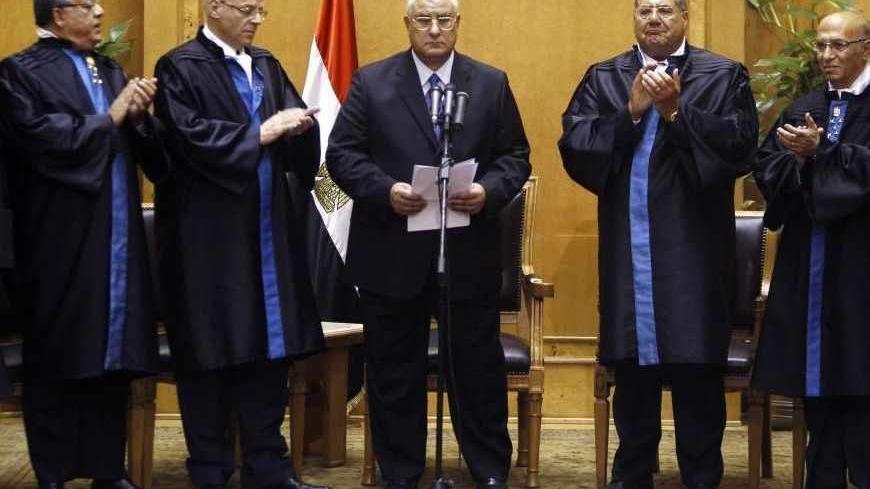 Adli Mansour (C), Egypt's chief justice and head of the Supreme Constitutional Court, is applauded by other judges after his swearing in ceremony as the nation's interim president in Cairo July 4, 2013, a day after the army ousted Mohamed Mursi as head of state. REUTERS/Amr Abdallah Dalsh (EGYPT - Tags: POLITICS CIVIL UNREST MILITARY TPX IMAGES OF THE DAY) - RTX11C5B