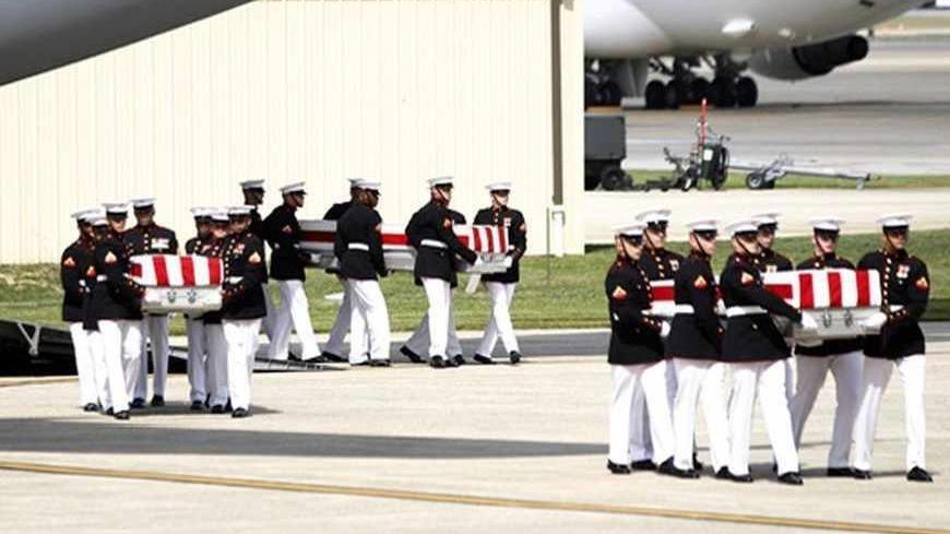 The remains of the U.S. ambassador and three other Americans killed in an attack in Libya are taken off a transport aircraft during a return of remains ceremony at Andrews Air Force Base near Washington, September 14, 2012. Ambassador Christopher Stevens and the other Americans died after gunmen attacked the lightly fortified U.S. consulate and a safe house refuge in Benghazi on Tuesday night. REUTERS/Jason Reed (UNITED STATES - Tags: POLITICS) FOR BEST QUALITY IMAGE: ALSO SEE GF2E8AF0BLU01 - RTR37Z8J