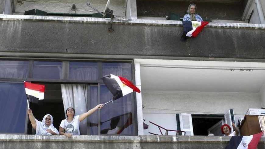 Women chant slogans from their windows to show their support for an anti-Mursi protest by police officers and protesters after the funeral of Brigadier General Mohamed Hani, a senior police officer from Alexandria, in the streets of Alexandria July 1, 2013.  Mohamed Hani was shot dead by unknown gunmen who ambushed his car in the Sinai Peninsula town of El Arish on Saturday, security sources and state media said.   REUTERS/Asmaa Waguih (EGYPT - Tags: POLITICS CIVIL UNREST) - RTX118S7
