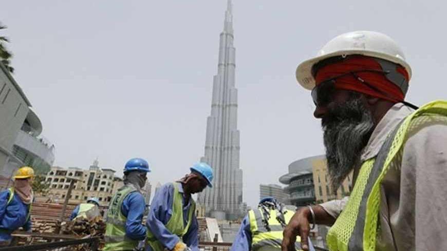 Labourers work near the Burj Khalifa, the tallest tower in the world, in Dubai May 9, 2013. REUTERS/Ahmed Jadallah (UNITED ARAB EMIRATES - Tags: BUSINESS CONSTRUCTION) - RTXZFXJ