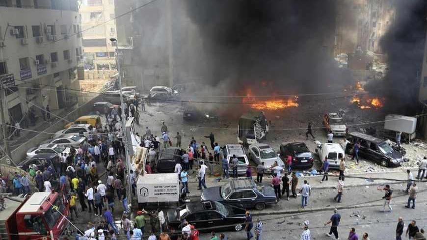 Civil Defence members, security personnel and civilians gather at the site of an explosion in Beirut's southern suburbs July 9, 2013. At least 18 people were wounded by a car bomb blast in Beirut's southern suburbs on Tuesday, a stronghold of the Lebanese Shi'ite Hezbollah militant group that has been fighting in Syria's civil war, security sources said. The sources were unable to confirm initial reports from medics at the scene that an unspecified number were killed in the massive blast. REUTERS/Issam Kobe