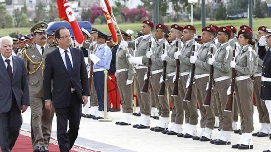 Tunisia's Minister of Defence Rachid Sabbagh (L) and French President Francois Hollande listen to their respective national anthems at the martyrs' mausoleum in Sijoumi in Tunis, July 5, 2013. REUTERS/Anis Mili (TUNISIA - Tags: POLITICS) - RTX11DA6