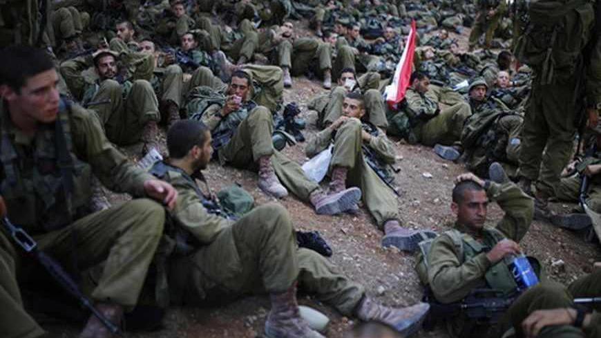 Israeli soldiers of the paratrooper brigade rest as they take a break during a march near Jerusalem, marking the completion of their advanced training, at the end of which they receive their red paratrooper beret June 27, 2013. REUTERS/Amir Cohen (ISRAEL - Tags: MILITARY) - RTX113ET