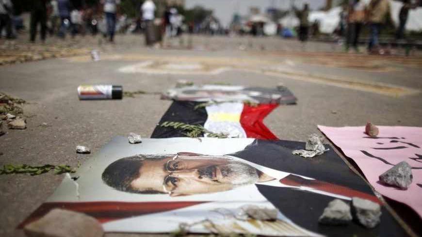 A portrait of deposed Egyptian President Mohamed Mursi in seen on the ground at the Raba El-Adwyia mosque square in Cairo July 6, 2013. Egypt counted its dead on Saturday after Islamists enraged by the overthrow of Mursi took to the streets in an explosion of violence against what they denounced as a military coup. REUTERS/Khaled Abdullah (EGYPT - Tags: POLITICS CIVIL UNREST) - RTX11ELU