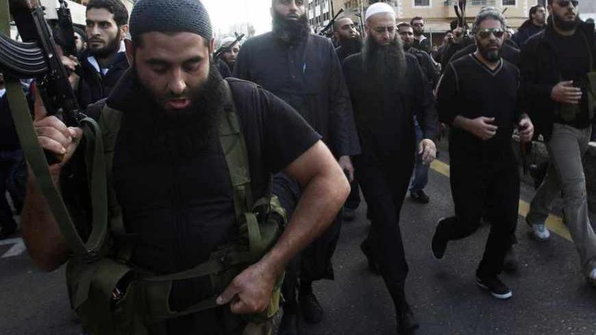 Armed supporters of Lebanon's Sunni Muslim Salafist leader Ahmad al-Assir (front row 3rd R) escort him and Lebanese singer Fadel Shaker (front row 2nd R) during the funeral of two of al-Assir's supporters, who died during Sunday's fighting with supporters of Lebanon's Hezbollah, in Sidon, southern Lebanon November 12, 2012. Three people were killed on Sunday when fighting broke out in the Lebanese coastal city of Sidon between followers of al-Assir and supporters of the Lebanese Shi'ite guerrilla movement H