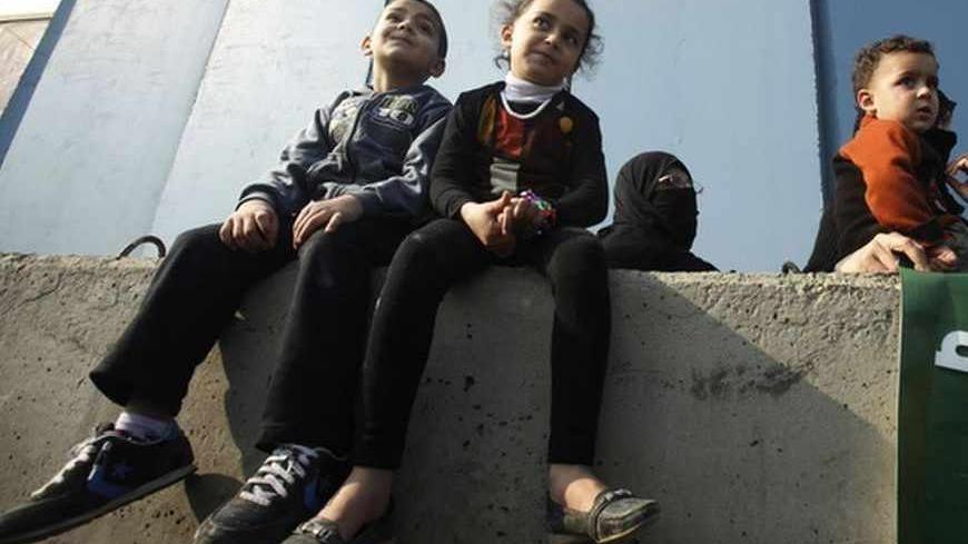 Palestinian Syrian refugee children sit on a concrete block during a demonstration in front of the United Nations Relief and Works Agency (UNRWA) in Beirut January 2, 2013. The demonstration, organised by the Islamic resistance movement Hamas, was held to ask the UNRWA for help in improving the refugees' living conditions.   REUTERS/Sharif Karim (LEBANON - Tags: SOCIETY IMMIGRATION POLITICS CIVIL UNREST) - RTR3C1NY