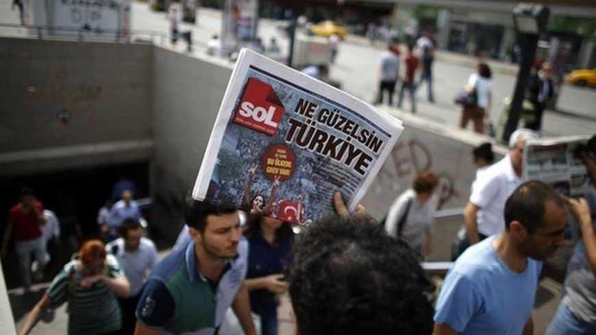 A man sells newspapers to people as they leave the subway station at Taksim Square in Istanbul June 4, 2013. Pockets of protesters clashed with Turkish riot police overnight and a union federation began a two-day strike on Tuesday as anti-government demonstrations in which two people have died stretched into a fifth day. Hundreds of police and protesters have been injured since Friday, when a demonstration to halt construction in a park in an Istanbul square grew into mass protests against a heavy-handed po