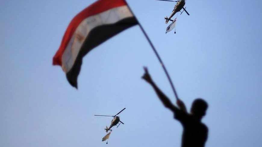 Egyptian military helicopters trailing national flags circled over Tahrir Square during a protest demanding that Egyptian President Mohamed Mursi resign in Cairo July 1, 2013. Five Egyptian military helicopters trailing national flags circled over Cairo on Monday after the armed forces gave politicians 48 hours to resolve a crisis over calls for the resignation of Islamist President Mohamed Mursi. REUTERS/Suhaib Salem (EGYPT - Tags: POLITICS CIVIL UNREST MILITARY TPX IMAGES OF THE DAY) - RTX1193S