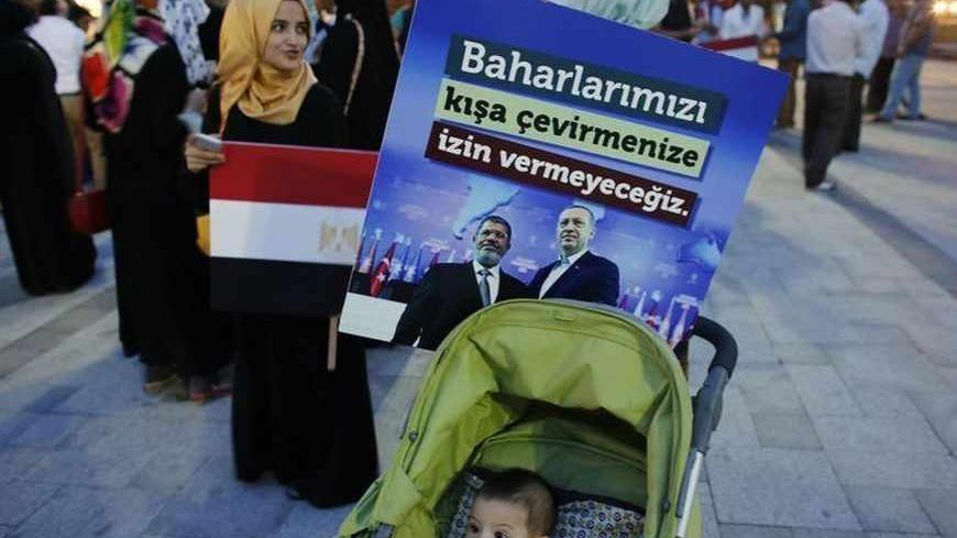A poster with the pictures of Egypt's President Mohamed Mursi and Turkey's Prime Minister Tayyip Erdogan (R) is attached to a baby stroller during a pro-Islamist demonstration in Istanbul July 1, 2013. Pro-Islamist groups held a demonstration in Istanbul in support of Mursi on Tuesday. Egypt's armed forces handed Islamist President Mohamed Mursi a virtual ultimatum to share power on Monday, giving feuding politicians 48 hours to compromise or have the army impose its own road map for the country. The slogan