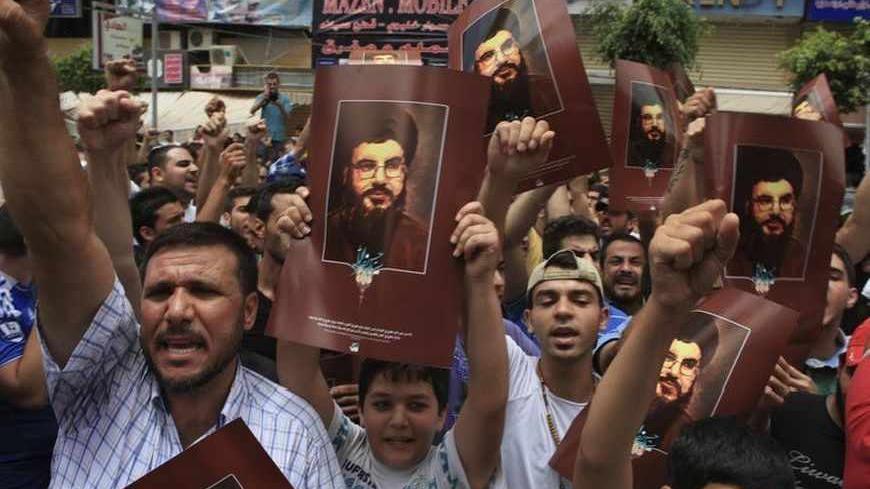 Supporters of Lebanon's Hezbollah leader Sayyed Hassan Nasrallah carry his pictures and shout slogans near the site of an explosion in Beirut's southern suburbs, July 9, 2013. A car bomb exploded on Tuesday in a Beirut stronghold district of the Lebanese Hezbollah militant group that has been fighting in Syria's civil war, wounding at least 38 people, a hospital official told Reuters. REUTERS/Khalil Hassan  (LEBANON - Tags: POLITICS CIVIL UNREST) - RTX11HIU