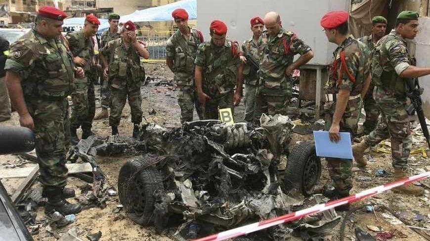Lebanese military police inspect the remains of a vehicle, at the site of an explosion in Beirut's southern suburbs, July 9, 2013. A car bomb exploded on Tuesday in a Beirut stronghold district of the Lebanese Hezbollah militant group that has been fighting in Syria's civil war, wounding at least 38 people, a hospital official told Reuters. REUTERS/Hasan Shaaban (LEBANON - Tags: POLITICS CIVIL UNREST TPX IMAGES OF THE DAY) - RTX11HK5