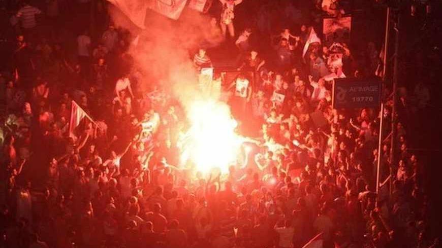 Protesters cheer and dance with flares as they gather for a mass protest to support the army in front of the presidential palace in Cairo July 26, 2013. At least seven people were killed and hundreds wounded in scattered violence across Egypt during mass rallies for and against the army's overthrow of Islamist President Mohamed Mursi, who was placed under investigation for murder. REUTERS/Asmaa Waguih (EGYPT - Tags: POLITICS CIVIL UNREST) - RTX120O6