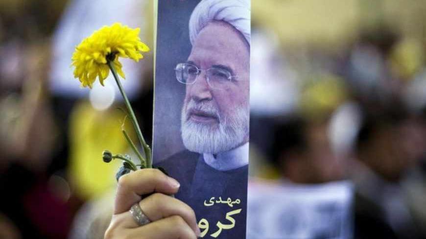 A supporter holds up a picture of presidential candidate Mehdi Karroubi during a rally in Tehran May 29, 2009. REUTERS/Raheb Homavandi (IRAN POLITICS ELECTIONS IMAGES OF THE DAY) - RTXOXBN