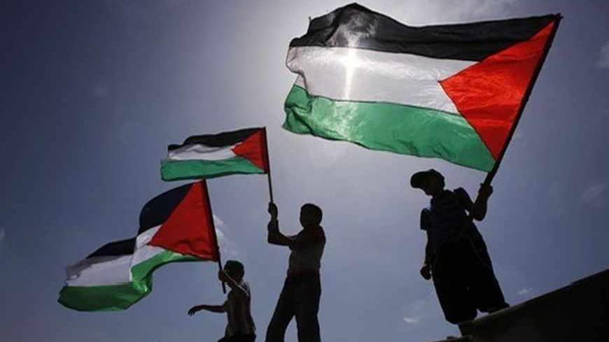 Boys wave Palestinian flags during a protest near the border between Israel and the northern Gaza Strip June 7, 2013. The protest was part of the Global March to Jerusalem initiative, marking the 46th anniversary of Israel's capture of East Jerusalem in the 1967 Middle East war. REUTERS/Suhaib Salem (GAZA - Tags: POLITICS CIVIL UNREST ANNIVERSARY) - RTX10F3F