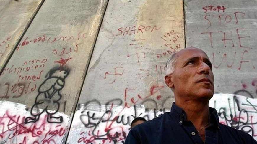 The Israeli nuclear whistleblower Mordechai Vanunu stands in front of separation wall during a protest against controversial Israeli security barrier in East Jerusalem.  The Israeli nuclear whistleblower Mordechai Vanunu who was freed from prison in April stands in front of the separation wall during a protest against the controversial Israeli security barrier in East Jerusalem August 27, 2004. The grandson of Mahatma Gandhi told Palestinian protesters at Israel's West Bank barrier on Friday that the wall r