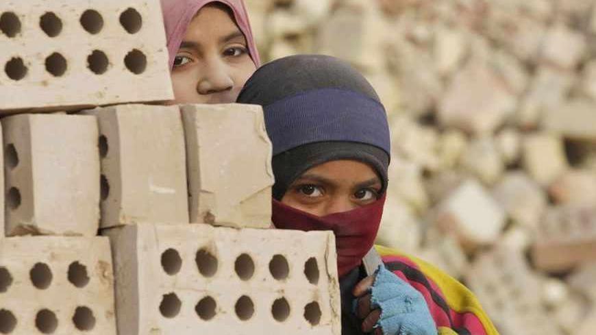 Iraqi women work in the brick factory in the town of Nahrawan east of Baghdad, March 8, 2012. REUTERS/Thaier al-Sudani (IRAQ - Tags: SOCIETY BUSINESS EMPLOYMENT) - RTR2Z1EF
