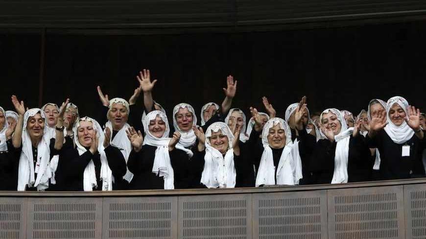 Supporters of Turkey's Prime Minister Tayyip Erdogan (not pictured) cheer as he addresses the members of parliament from his ruling AK Party (AKP) during a meeting at Turkish parliament in Ankara June 25, 2013. Turkish anti-terrorism police detained 20 people in raids in the capital Ankara on Tuesday in connection with weeks of anti-government protests across the country, media reports said. REUTERS/Umit Bektas (TURKEY - Tags: POLITICS) - RTX11029