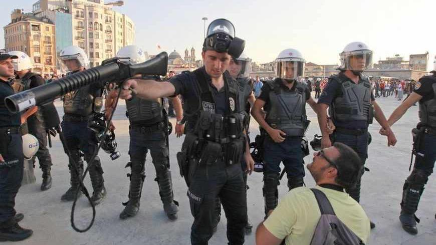 A riot police officer orders a news photographer to move away during an anti-government protest in central Istanbul July 28, 2013. REUTERS/Osman Orsal (TURKEY - Tags: POLITICS CIVIL UNREST TPX IMAGES OF THE DAY) - RTX12327