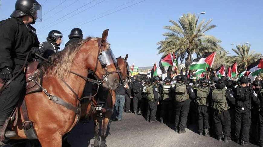 Israeli mounted policemen guard as Israeli-Arab protesters wave Palestinian flags during a demonstration to show their solidarity with Bedouin citizens, in the Israeli-Arab town of Umm el-Fahm August 1, 2013. Hundreds demonstrated on Thursday against an Israeli cabinet plan to relocate some 30,000 Bedouin citizens who live in unrecognized villages in Israel's southern Negev desert and relocate them to towns built by the government. Clashes erupted at the demonstration as police prevented the protesters from