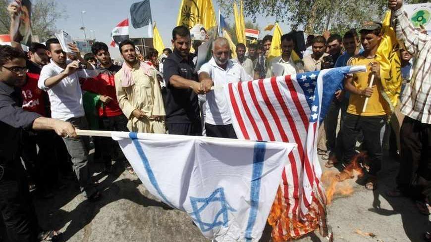 People burn an Israeli and a U.S. flag during a rally to mark "Al Quds" or Jerusalem Day, in Najaf, about 160 km (100 miles) south of Baghdad, August 2, 2013.                   REUTERS/Haider Ala (IRAQ - Tags: CIVIL UNREST POLITICS) - RTX1286E