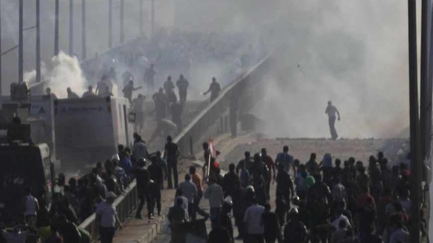Members of the Muslim Brotherhood and supporters of ousted Egyptian President Mohamed Mursi flee from tear gas and rubber bullets fired by riot police during clashes, on a bridge leading to Rabba el Adwia Square where they are camping, in Cairo August 14, 2013. At least 95 Egyptians were killed on Wednesday after security forces moved in on protesters demanding the reinstatement of Mursi, and the government imposed a state of emergency as unrest swept the most populous Arab nation. REUTERS/Amr Abdallah Dals